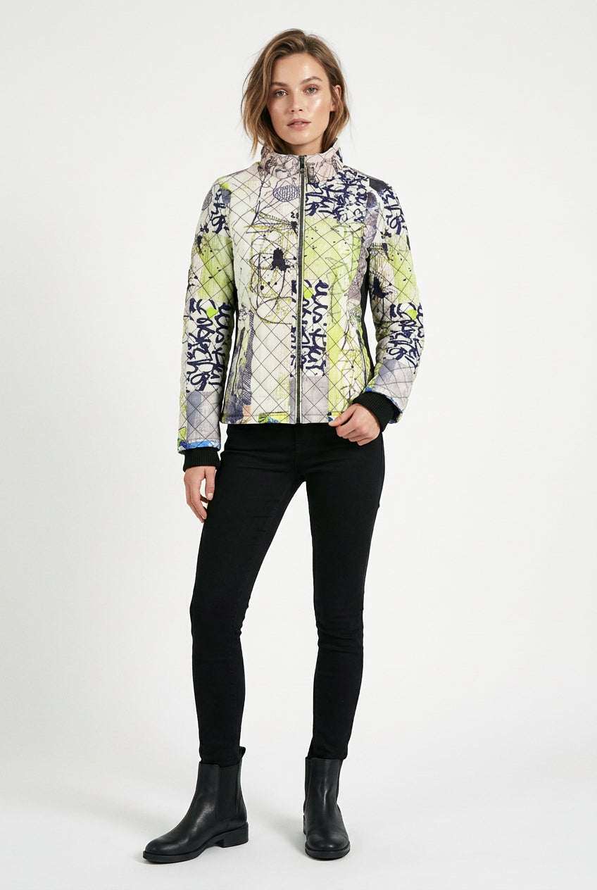 A women's quilted jacket featuring a vibrant abstract graffiti and paint-splatter pattern in lime green, navy blue, gray, and white, with a black interior lining.